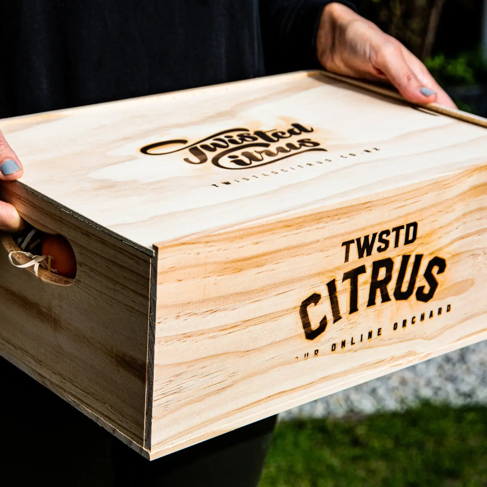 Person holding a wooden box with signage on it