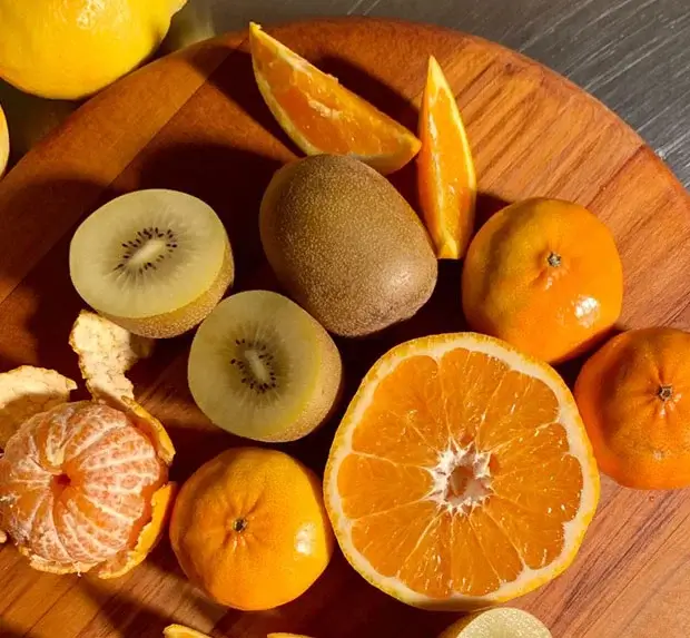 Assorted sliced fruits on a wooden chopping board