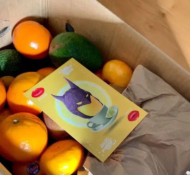 Open box of fruits with brown paper covering some of them