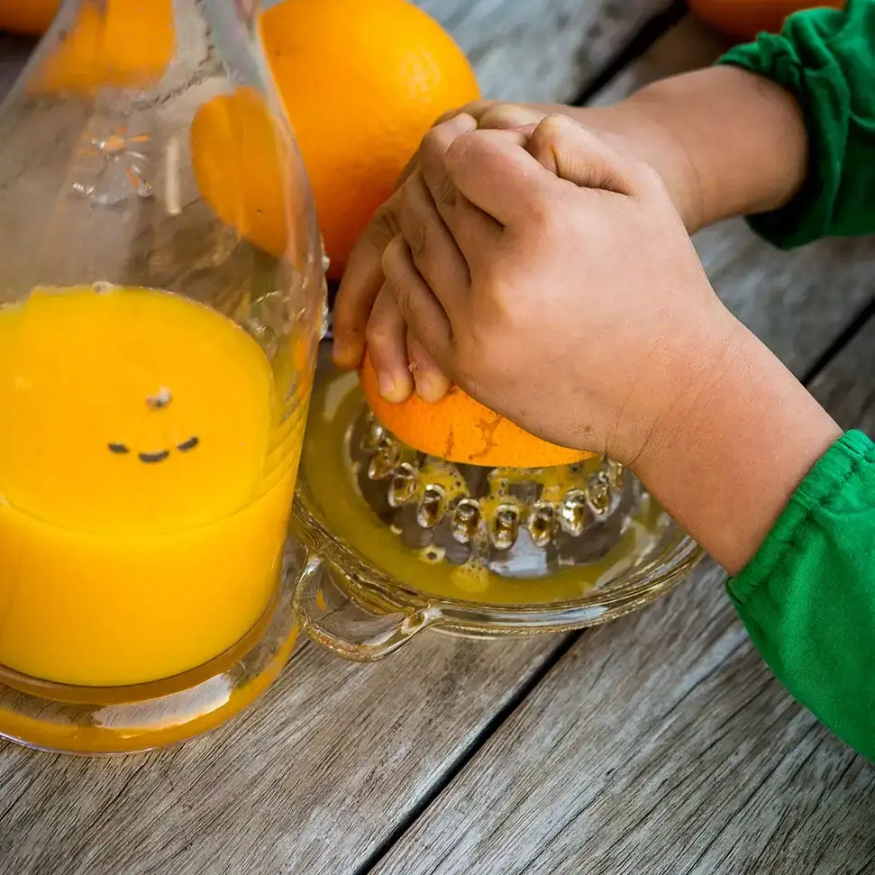 Orange being squeezed on a juicer